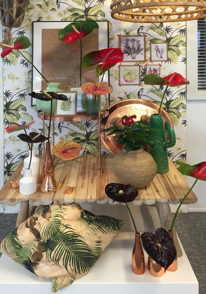 Tropical interior with bothanic prints, wicker lamp and anthurium